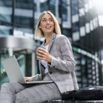 smiling-young-businesswoman-using-laptop-in-the-city.jpg